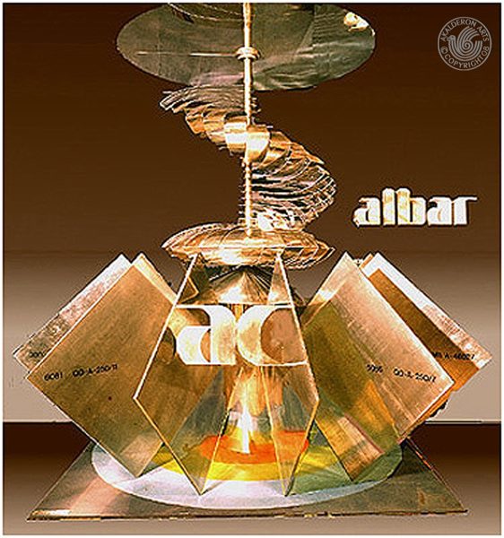 Kinetic sculpture 'Kinetic Sculpture': a spiral of golden discs mounted above angular reflective glass panels forming a star-like base, labelled 'albar'.