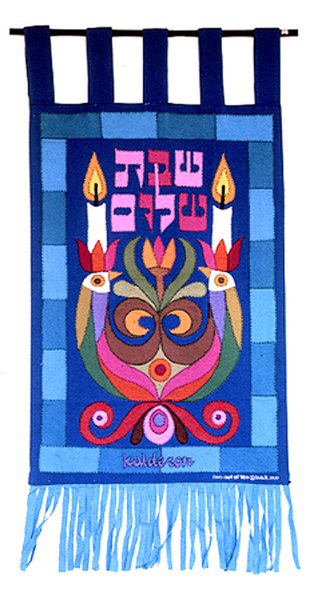 Tapestry 'Shabat Shalom': two candles flanking a stylised floral bird motif in maroon and gold, with Hebrew text above, on a blue background with fringed border.