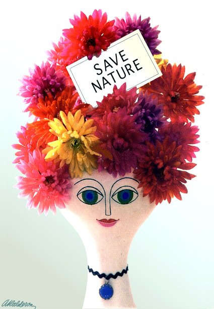 Poster 'Save Nature's Beauty': a sculpted mannequin head with painted eyes wears a wig made of vivid red, pink, purple and yellow chrysanthemums, holding a small sign that reads 'Save Nature'.